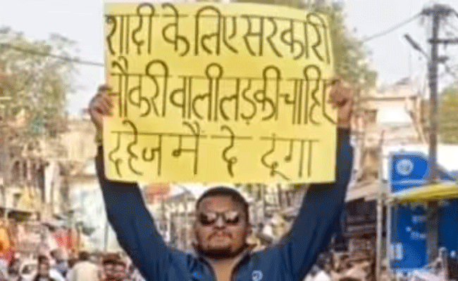 Read more about the article സർക്കാർ ഉദ്യോഗസ്ഥയായ വധുവിനെ ആവശ്യമുണ്ട്; പോസ്റ്ററും പിടിച്ച് മാർക്കറ്റിൽ യുവാവ്; വീഡിയോ വൈറൽ